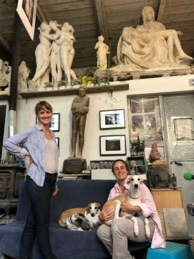 Flavia Robalo and Veronica Fonzo in stone sculpture studio with dog